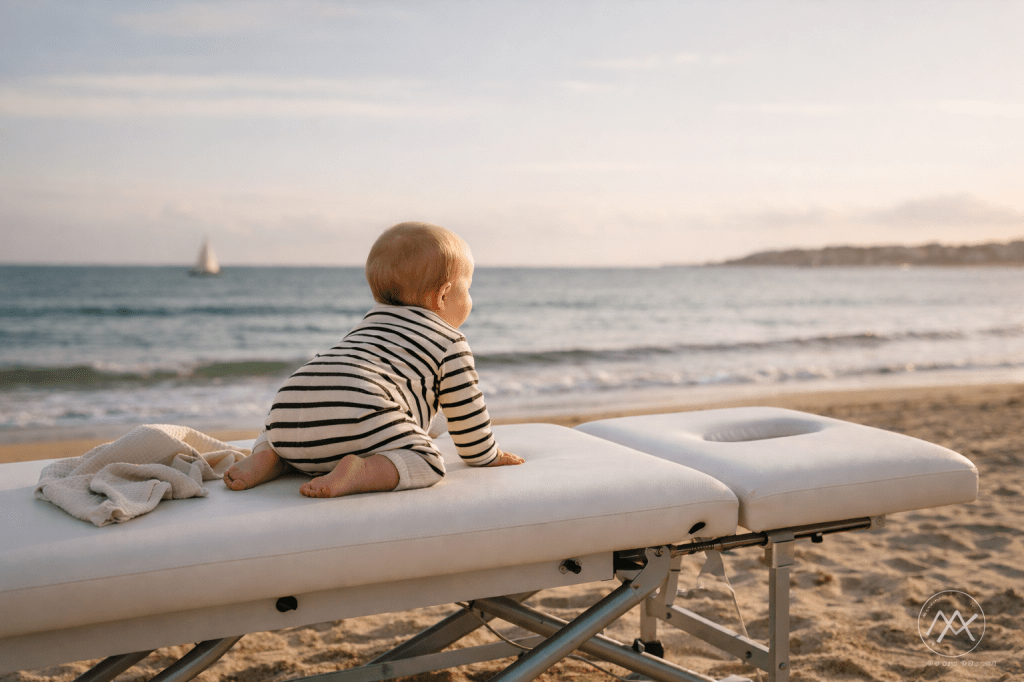 bébé sur table d’ostéopathie face à la mer – suivi du nouveau-né